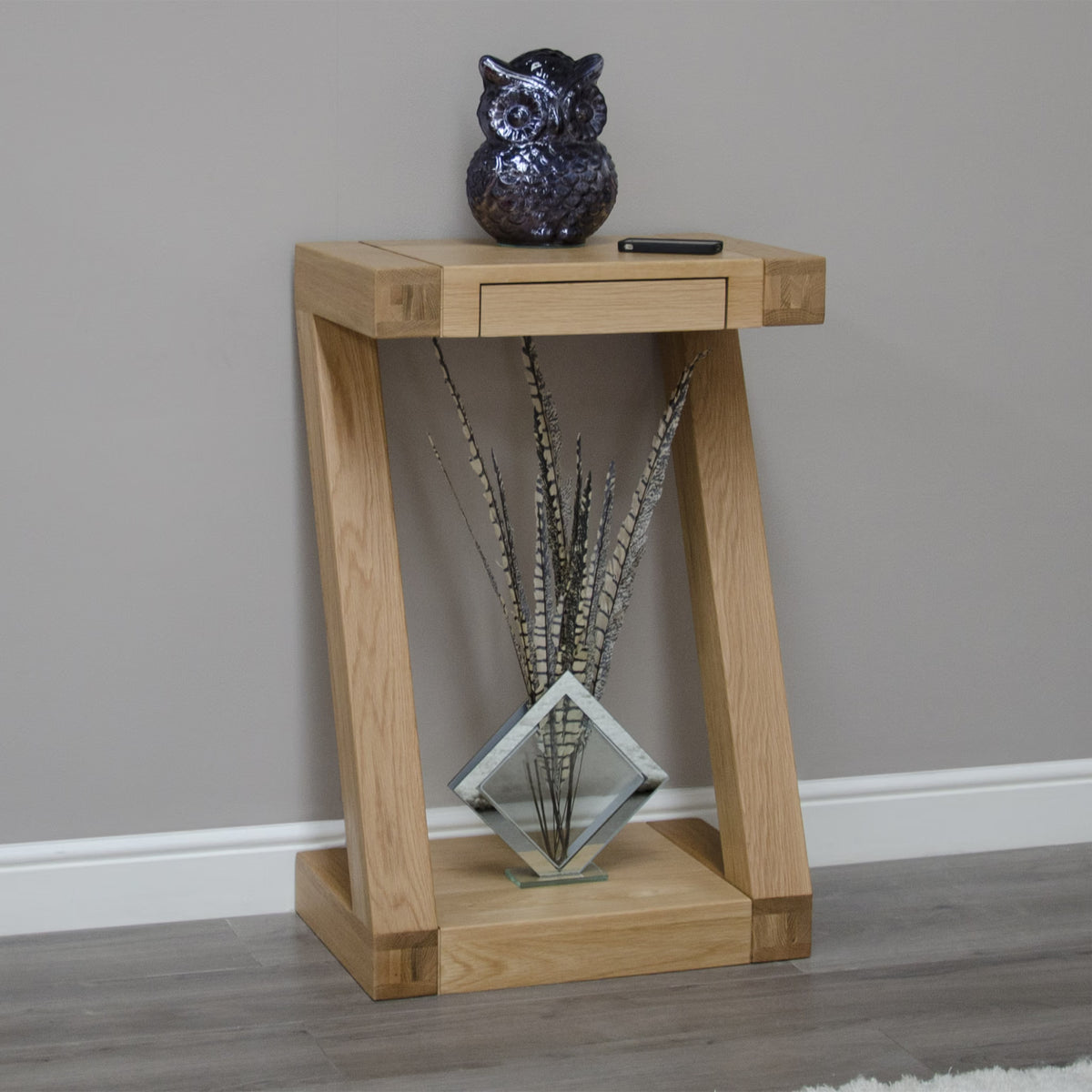 Oak console table with drawer, decorative vase and ceramic owl in modern hallway setting