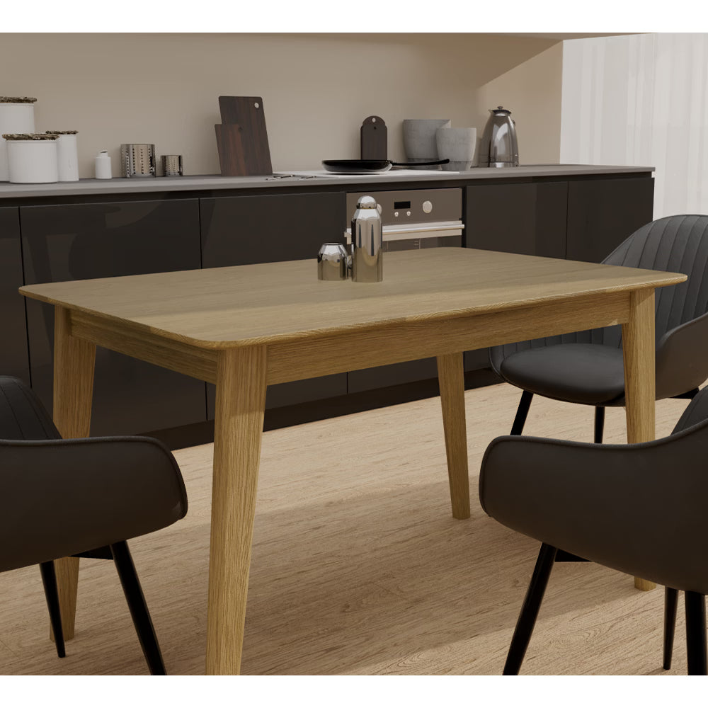 Oak dining table with black chairs in modern kitchen setting