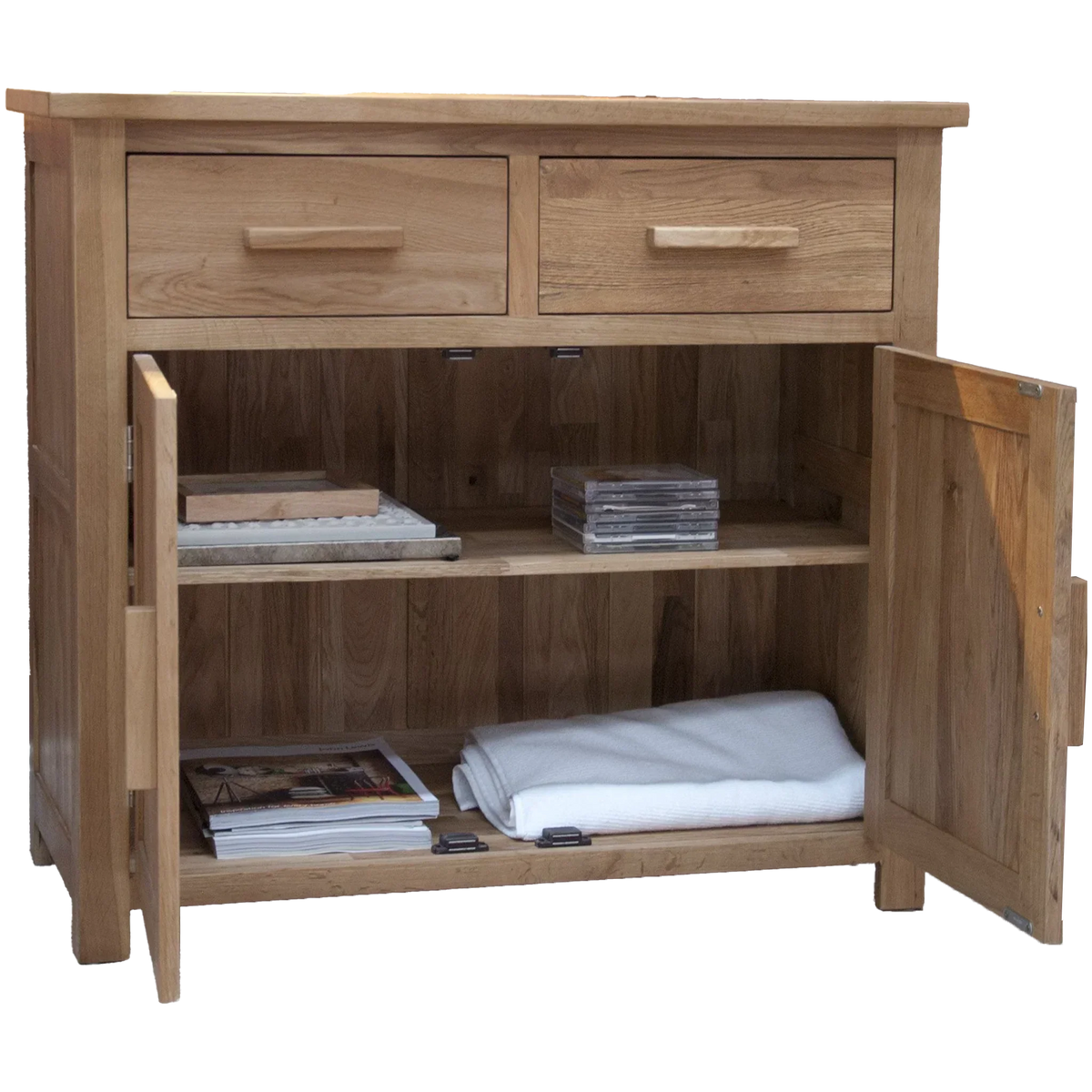 Oak sideboard with two drawers, open cabinet doors, shelves holding magazines and folded linen