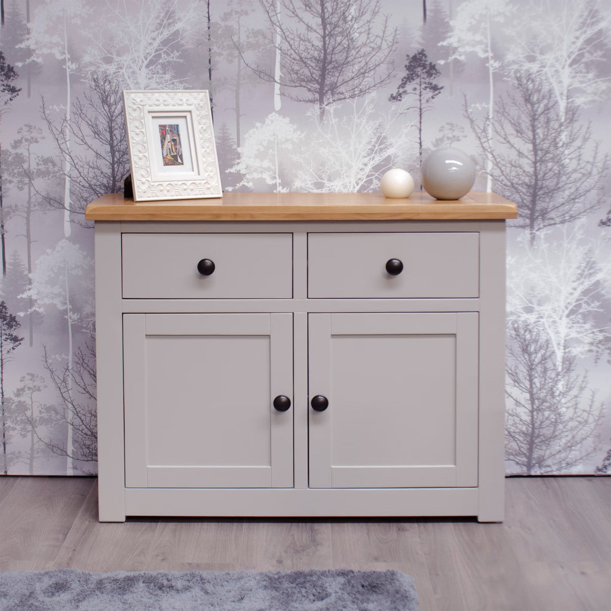 Grey sideboard with oak top, black knobs, two drawers, two doors, decor items on top