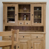 Oak dining room dresser with glass-front cabinets, drawers and shelves, next to wooden chairs