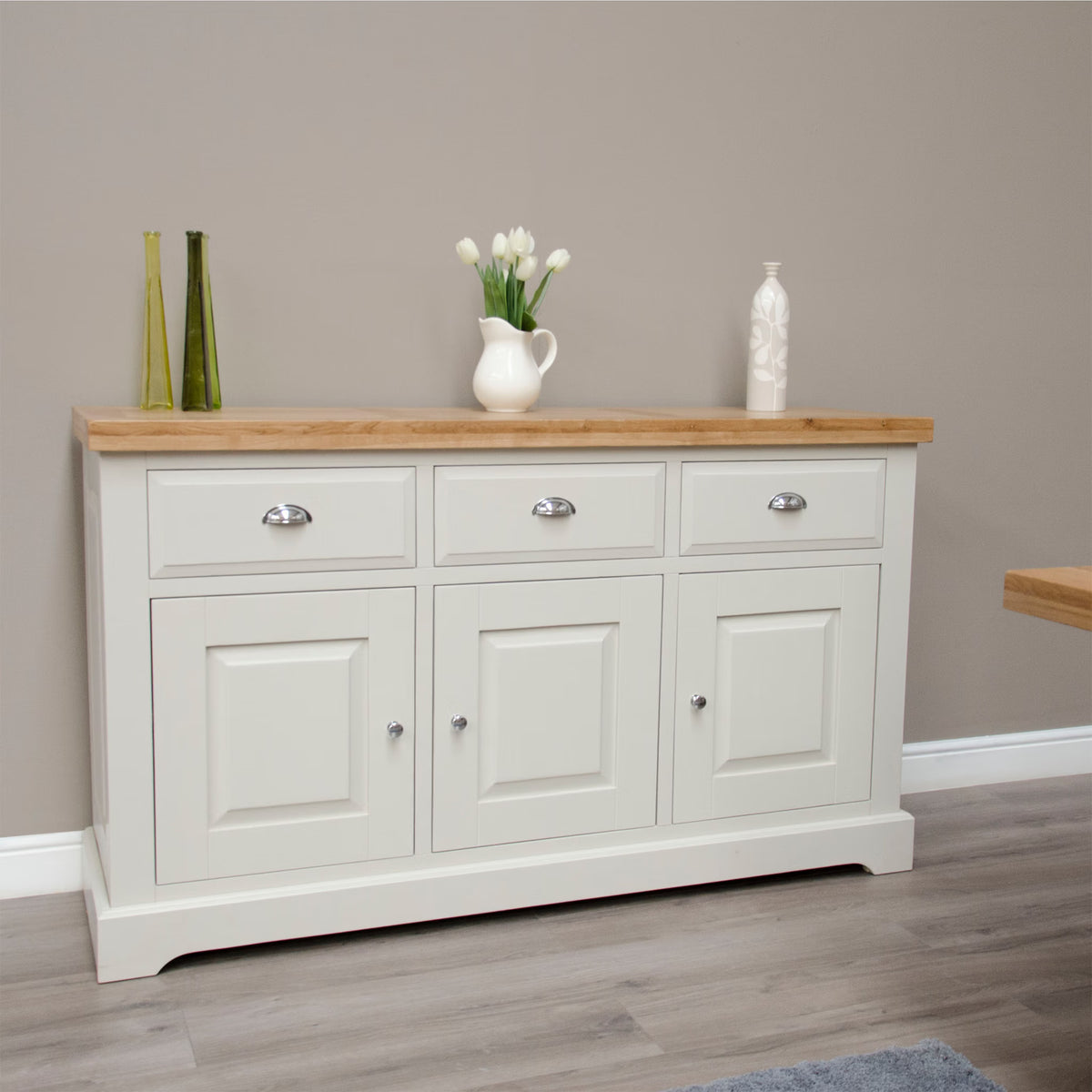Cream sideboard with oak top, three drawers, and cabinets in modern dining room