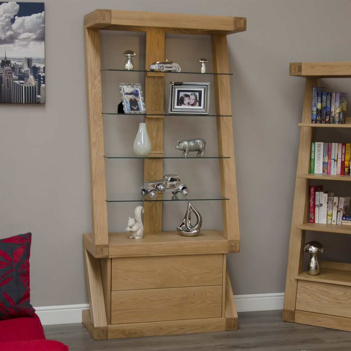 Oak display cabinet with glass shelves and drawers against beige wall with ornaments