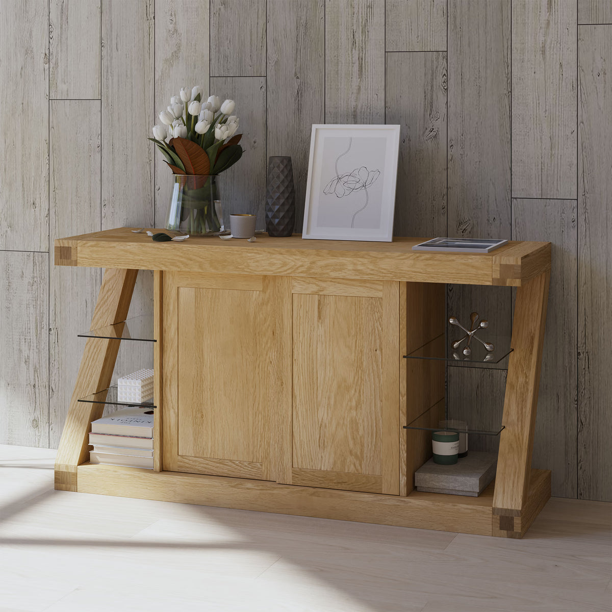 Light oak sideboard with sliding doors, glass shelves, books, and decorative items