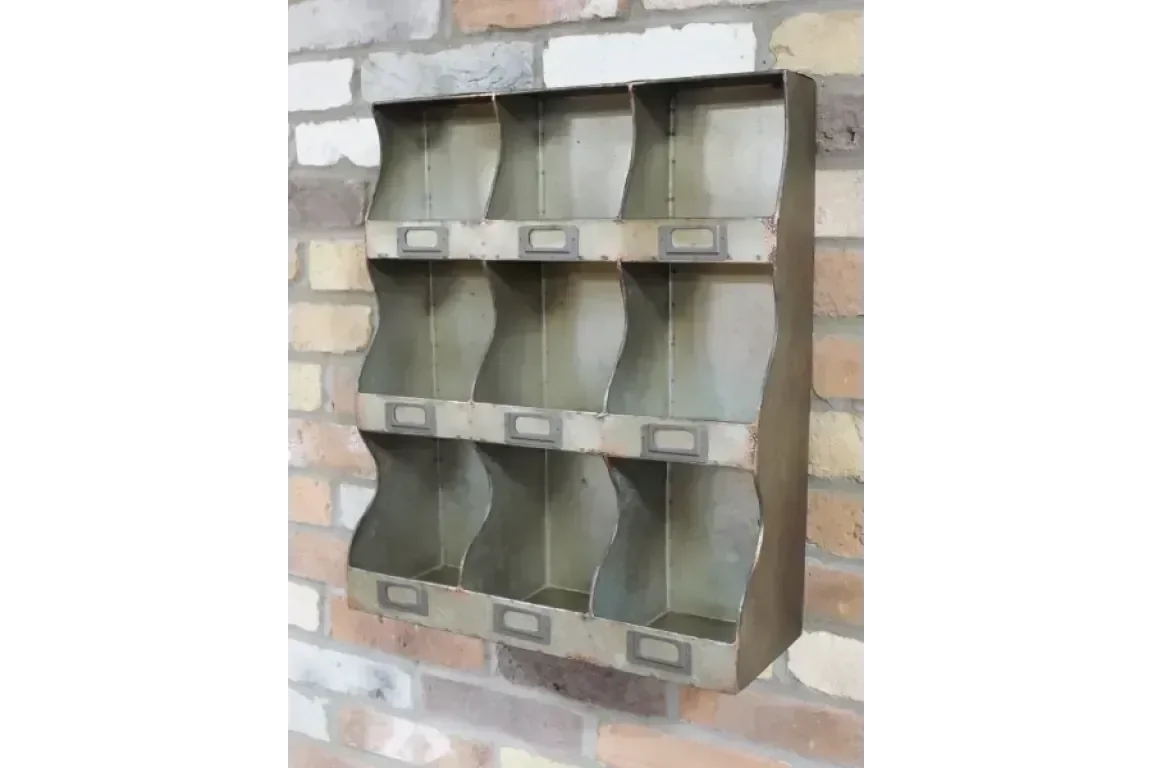 Industrial metal wall organiser with nine labelled storage compartments against brick wall