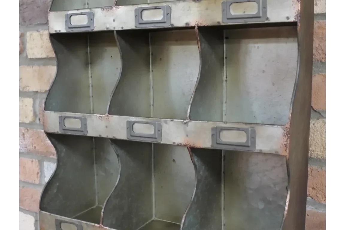 Industrial metal storage organizer with six compartments and label holders on brick wall