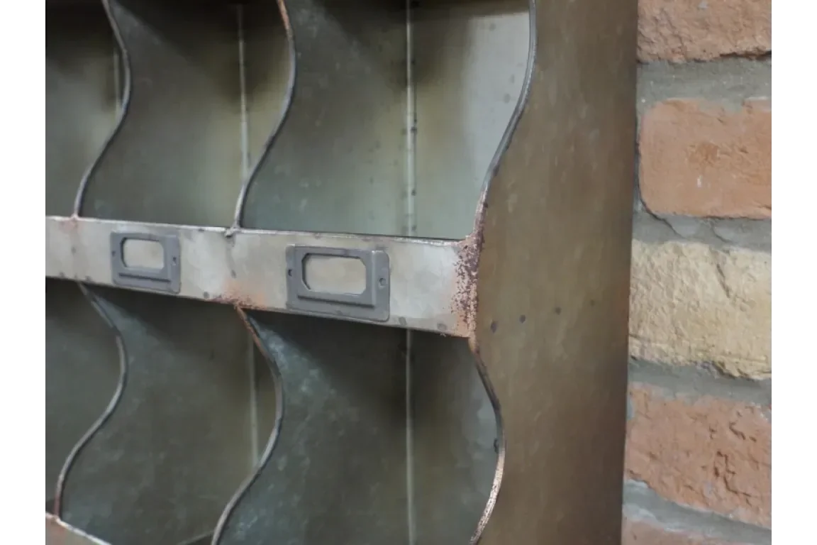 Industrial metal shelving unit with curved dividers and label holder, close-up view