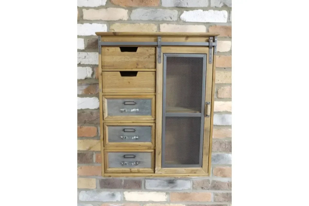Wall mounted wooden storage cabinet with metal drawers and mesh door against brick wall