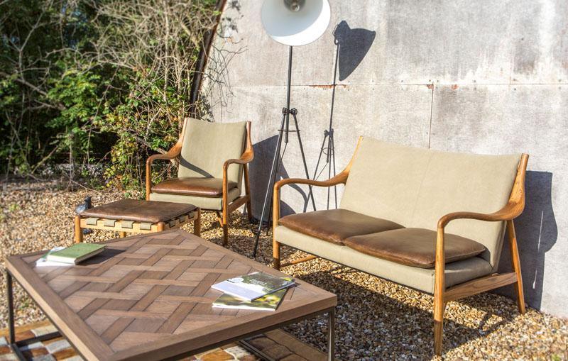 Outdoor wooden garden furniture set with beige cushions and coffee table on gravel patio