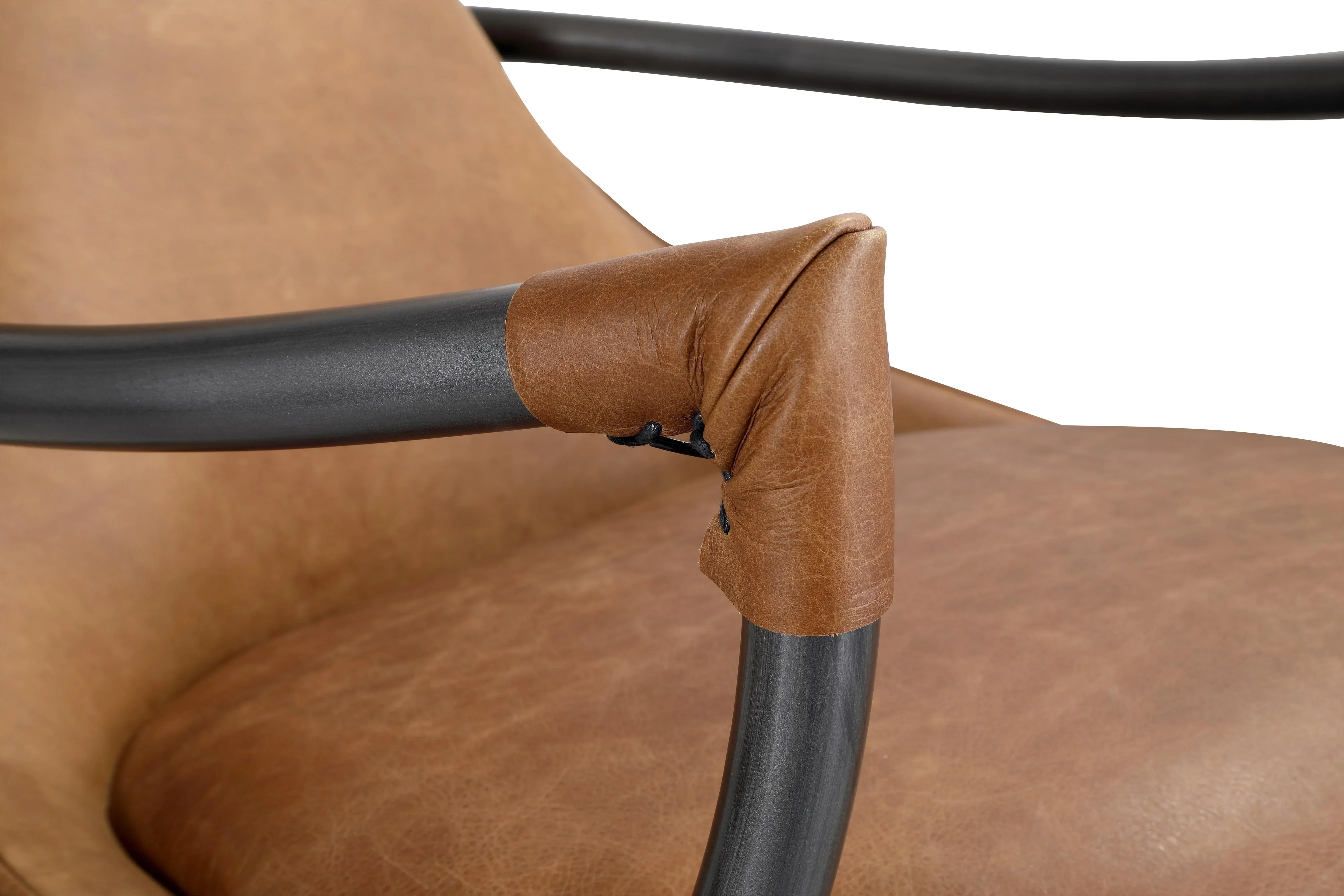 Closeup of brown leather armchair with black metal armrest and stitched leather detail