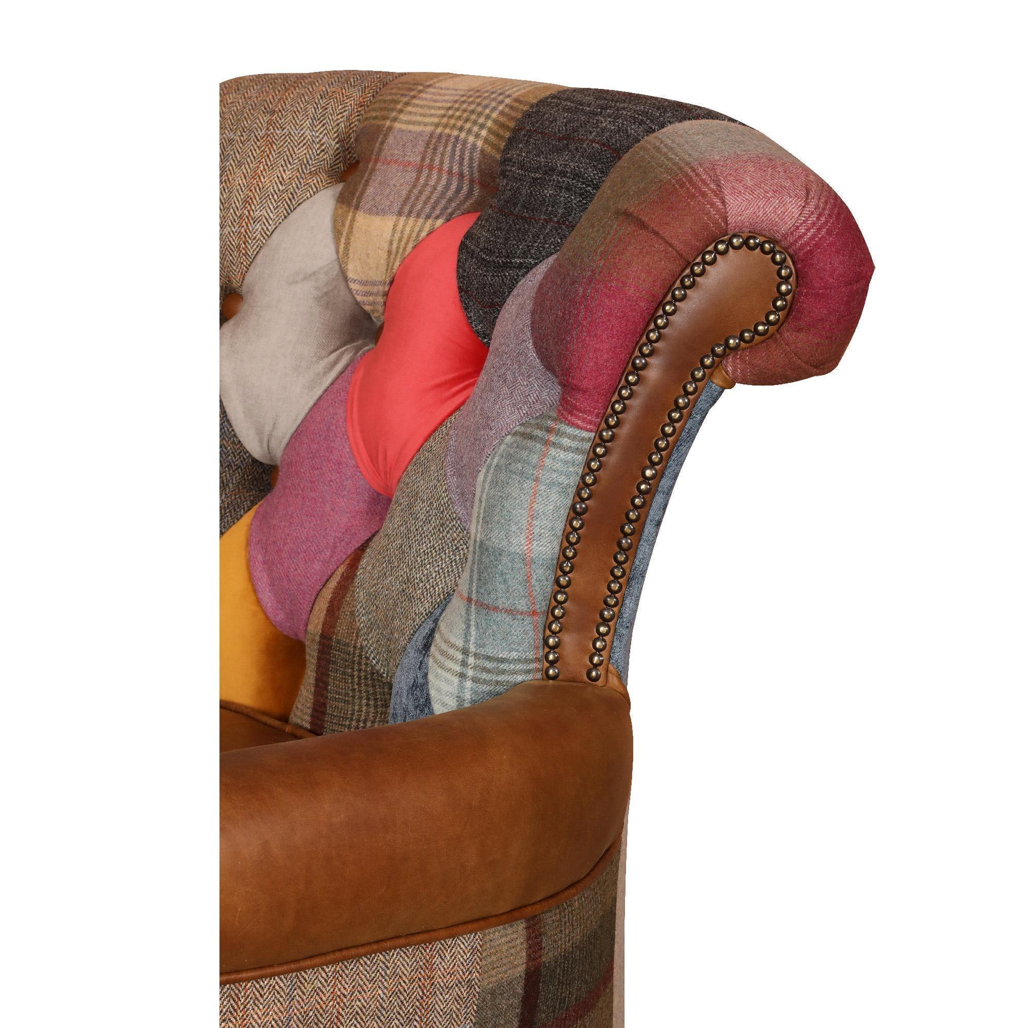 Patchwork armchair with multicolour fabric, brown leather armrest, and stud detailing