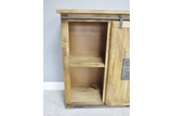 The Jupiter Industrial Wine Cabinet features a rustic wooden design with a sliding door, showcasing two open shelves for storage and a metal accent plate