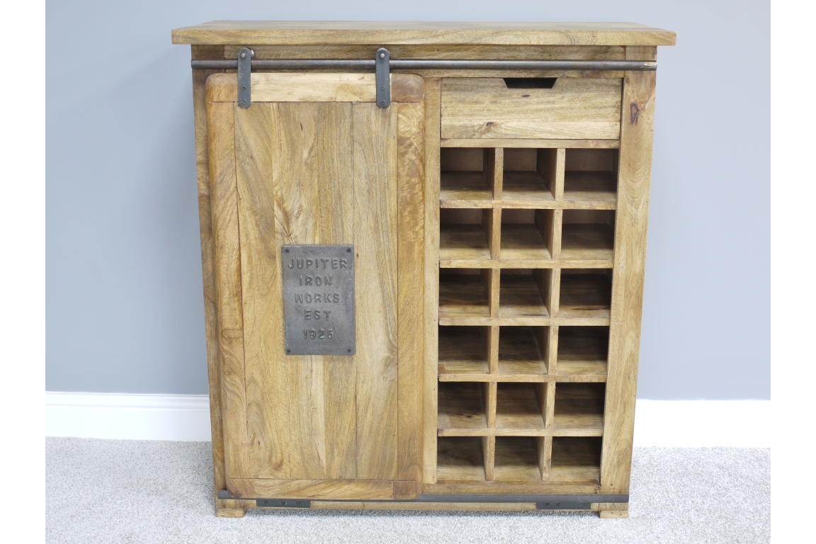The Jupiter Industrial Wine Cabinet features a rustic wooden design with a sliding door, a metal plaque, and multiple compartments for storing wine bottles