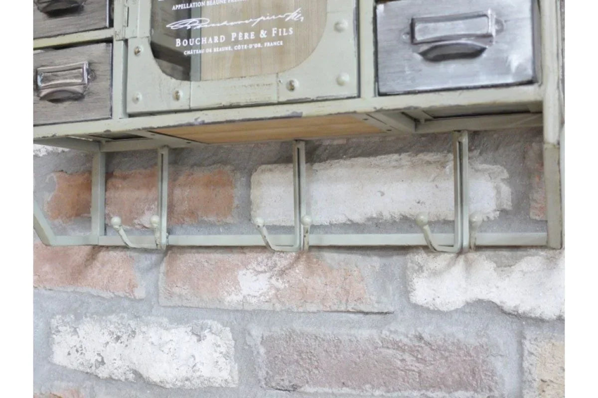 Wall mounted coat rack with metal hooks and storage drawers on exposed brick wall