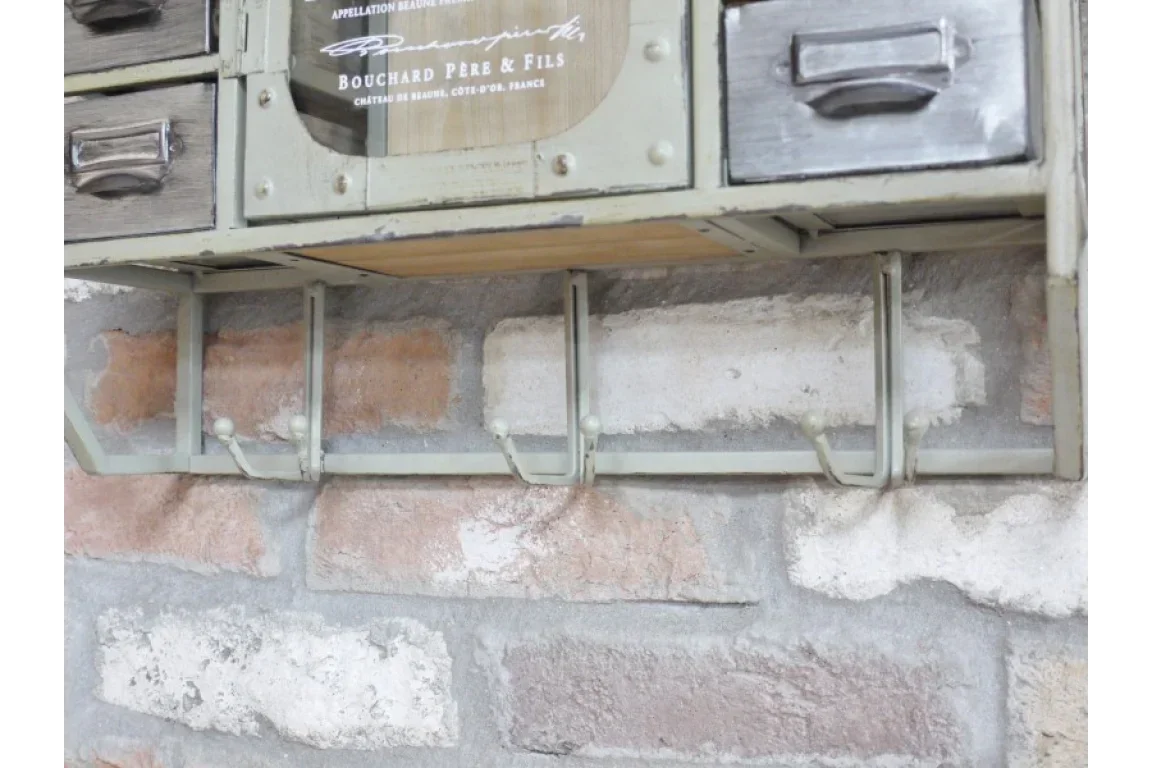 Industrial metal wall storage unit with hooks and drawers against brick wall