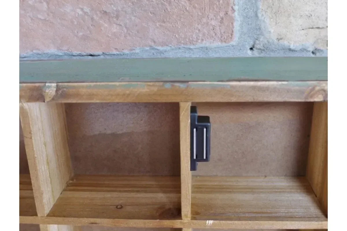 Wooden shelving unit close-up with open compartments and a black metal hook