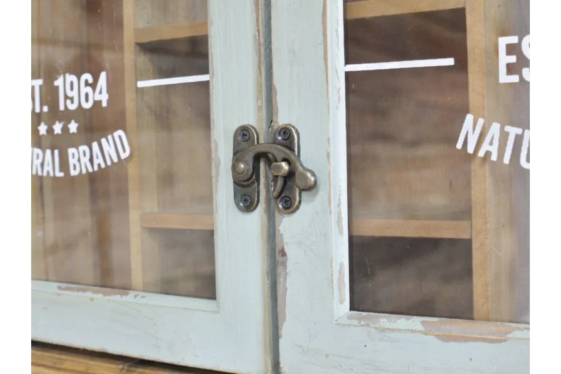 Close-up of distressed wood cabinet doors with glass panels and antique brass latch