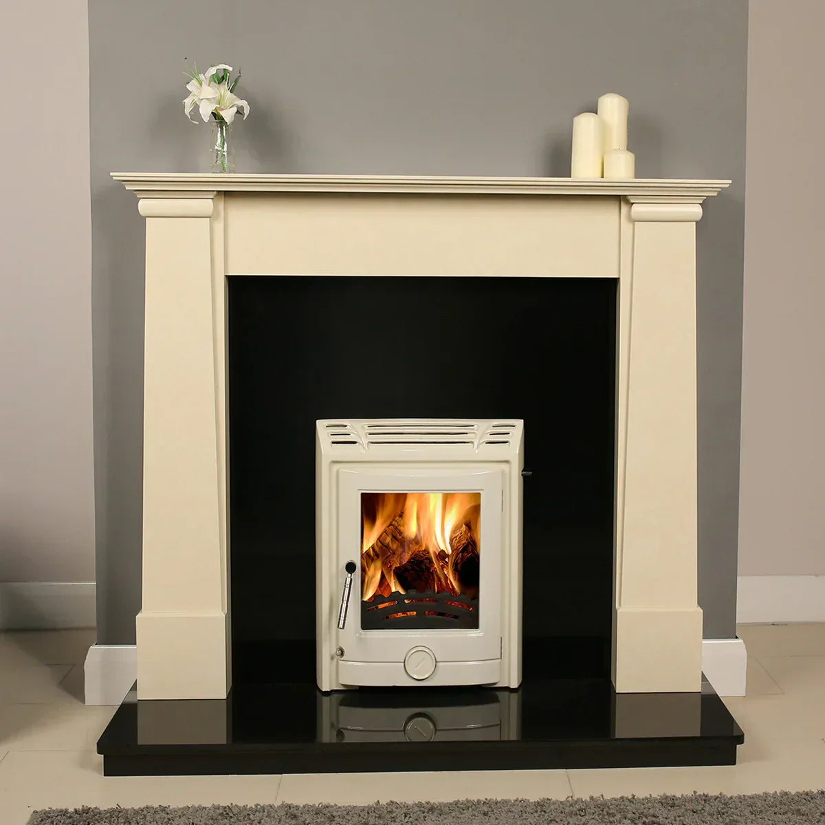 Ivory cream fireplace surround with lit wood burning stove on black hearth