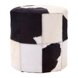 Round stool featuring a patchwork design of black and white hair-on leather, with a smooth top and sturdy base, suitable for various home decor styles