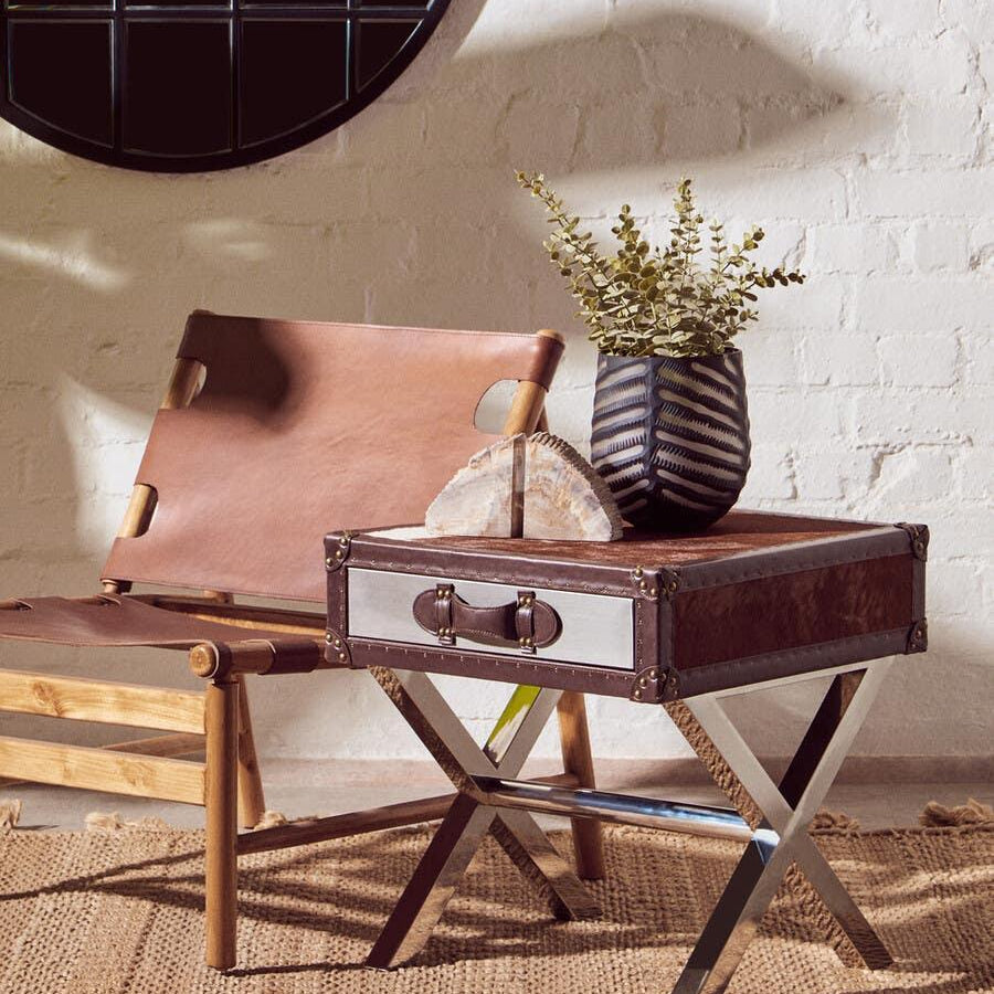 Leather accent chair and metal side table with decorative vase in modern living room
