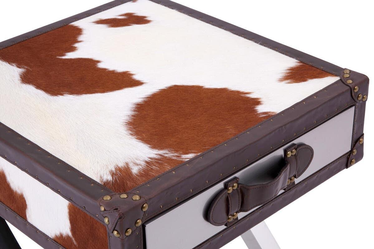 Brown and white cowhide side table with brass corner studs and leather handle