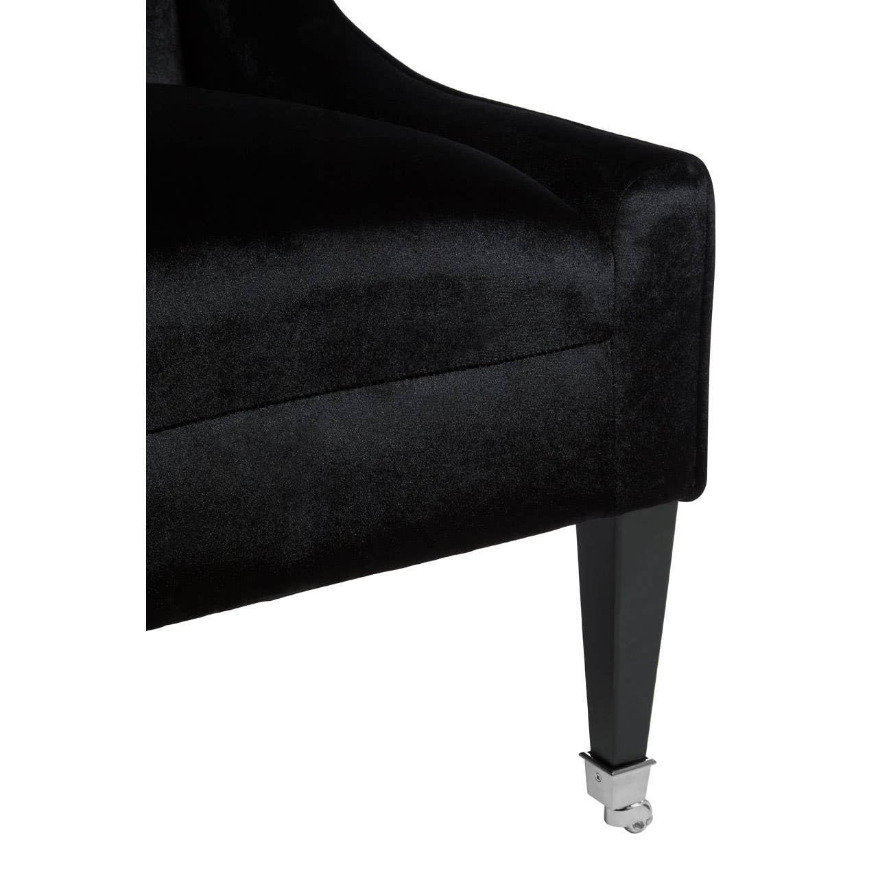 Black velvet chair corner with angular armrest and chrome castor leg detail