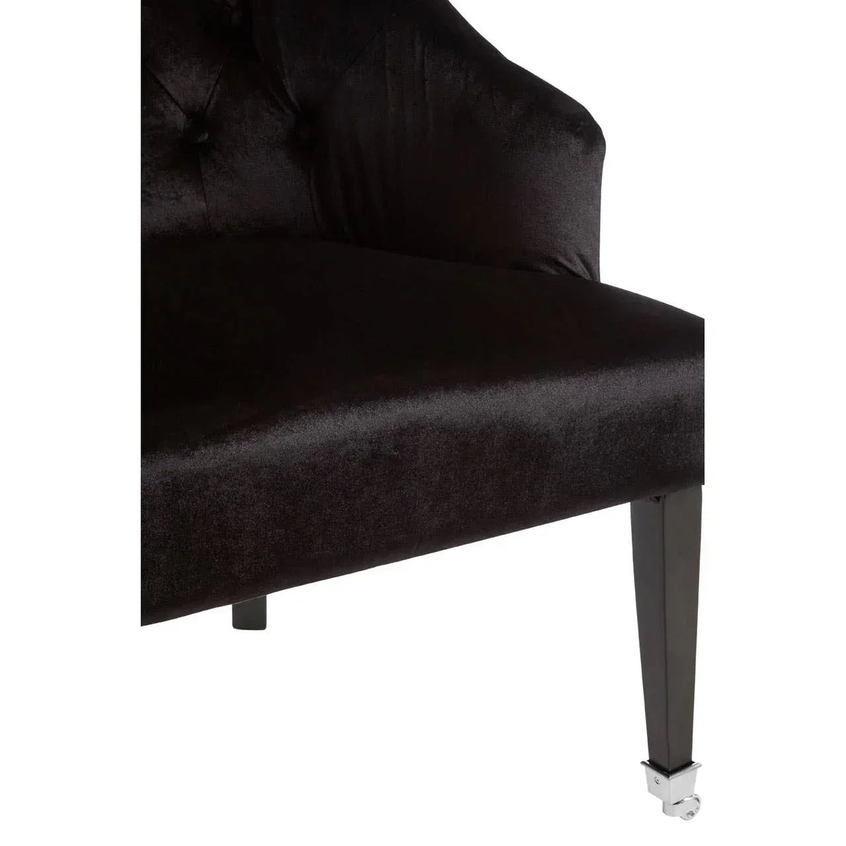 Dark velvet chair seat with button detail and black tapered front leg on caster
