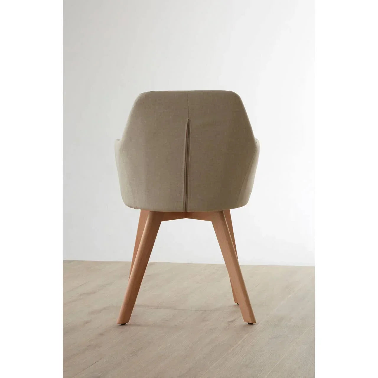Beige fabric dining chair with wooden legs, rear view on light wood floor