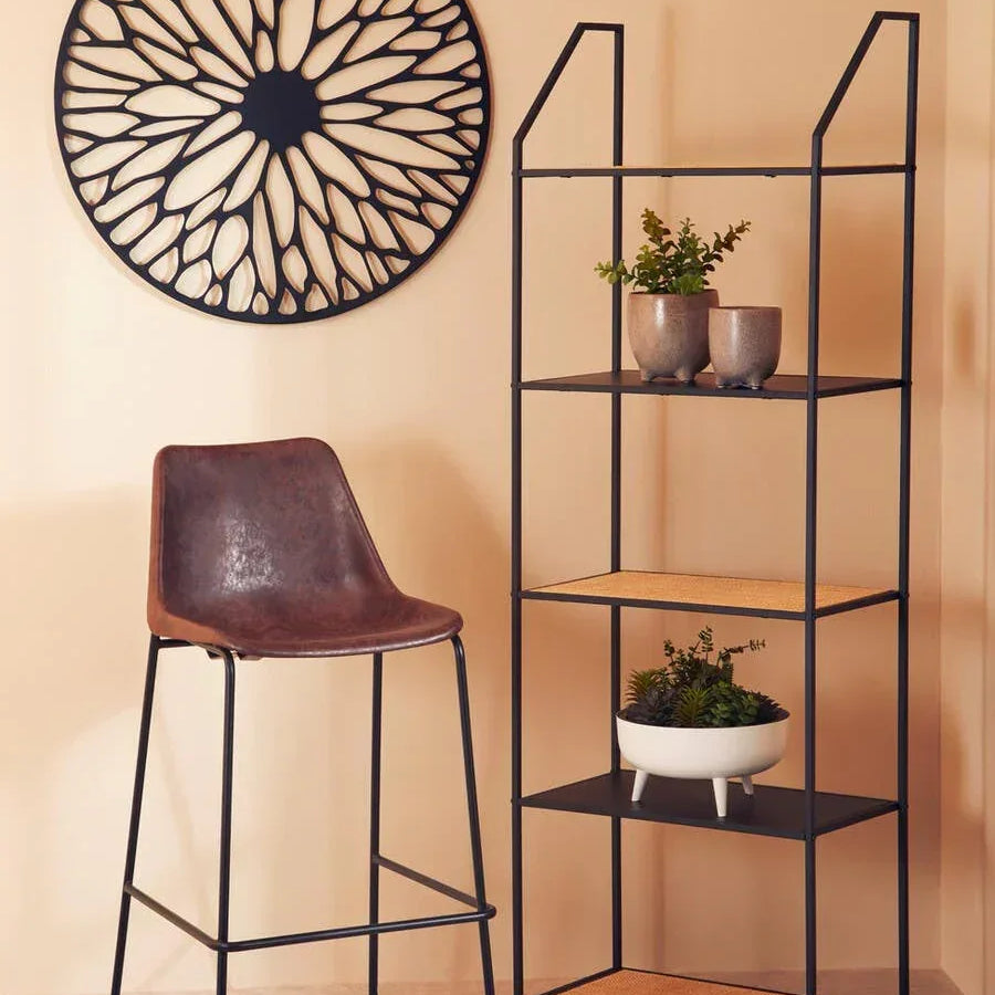 Brown faux leather bar stool with black metal frame next to black metal shelving unit and wall art