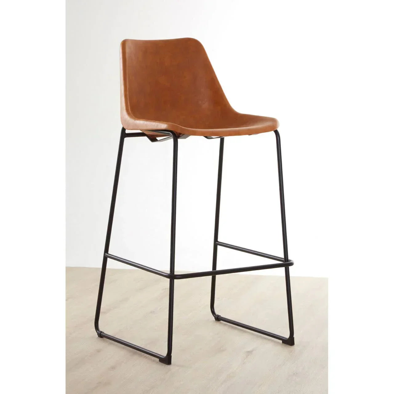 Brown faux leather bar stool with black metal legs on light wood floor