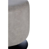 A round pouffe with a soft ash grey faux leather exterior, featuring a smooth surface and a slightly rounded top. The pouffe is supported by a sturdy black base, providing a modern and stylish accent for home decor