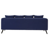 Navy fabric three-seater sofa with a sleek design, featuring four back cushions and tapered wooden legs, showcasing a modern and minimalist aesthetic