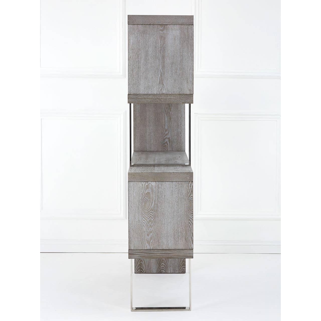 Tall grey wood storage cabinet with closed doors and metal legs against white wall