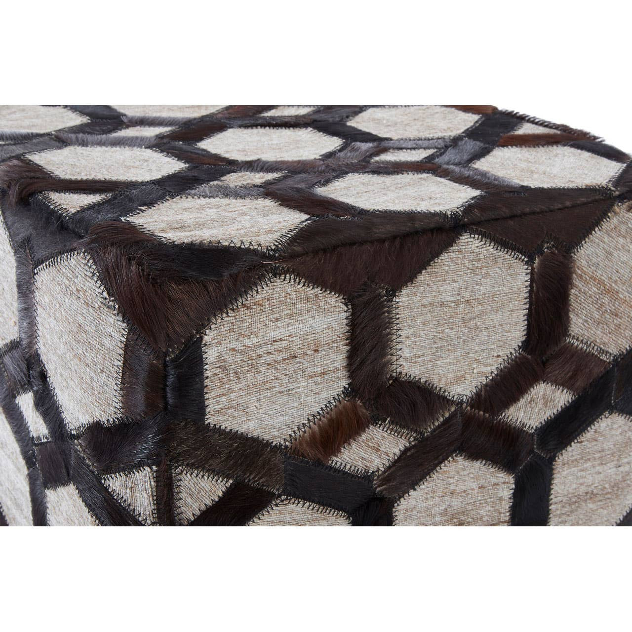 A close-up view of a grey leather patchwork pouffe featuring a geometric design with hexagonal shapes in dark brown and light grey tones, showcasing the texture and stitching details