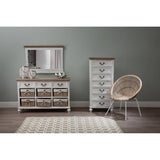 Hendra Storage Cabinet featuring six willow baskets, positioned next to a tall, narrow cabinet and a round, woven chair, all set against a soft green wall. A mirror is placed above the cabinet, and a light-colored area rug is visible on the floor