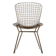 Bronze metal wire chair with a grid frame design, featuring a rounded backrest and armrests, supported by slender legs. The chair has a modern and minimalist aesthetic, suitable for various home decor styles