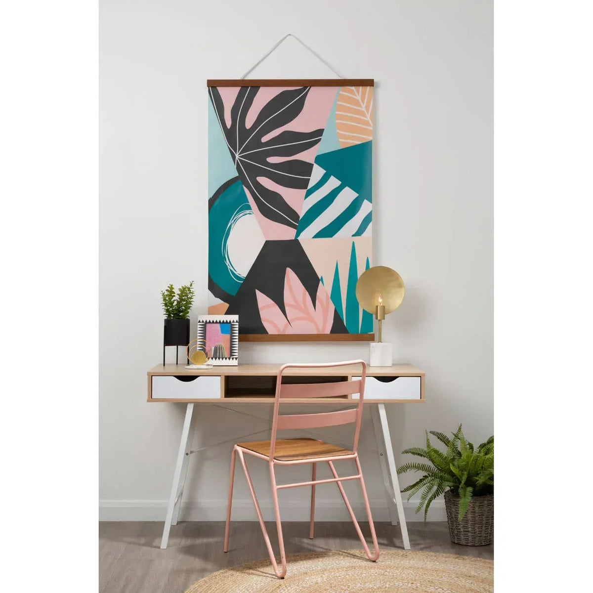Modern writing desk with drawers, pink metal chair and abstract wall art in home office setup