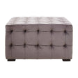 Grey velvet stool featuring a button-tufted design with a rectangular shape and dark wooden legs. The surface is plush and smooth, showcasing a sophisticated and modern aesthetic