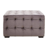 Grey velvet stool featuring a button-tufted design with a rectangular shape and dark wooden legs. The surface is plush and smooth, showcasing a sophisticated and modern aesthetic