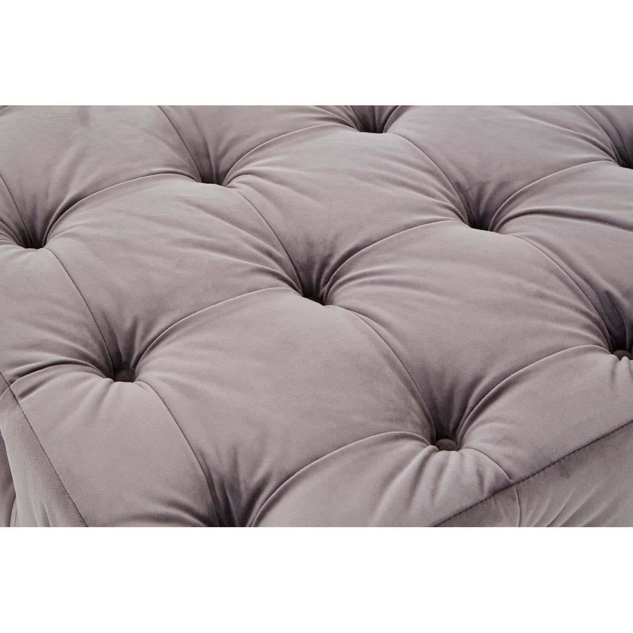 Soft grey velvet fabric with a button-tufted design, featuring deep indentations and a plush texture, creating a luxurious and inviting appearance