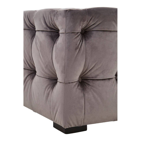Grey velvet stool with a button-tufted design, featuring a square shape and a sturdy base. The fabric has a soft texture, and the tufting creates a plush, elegant appearance