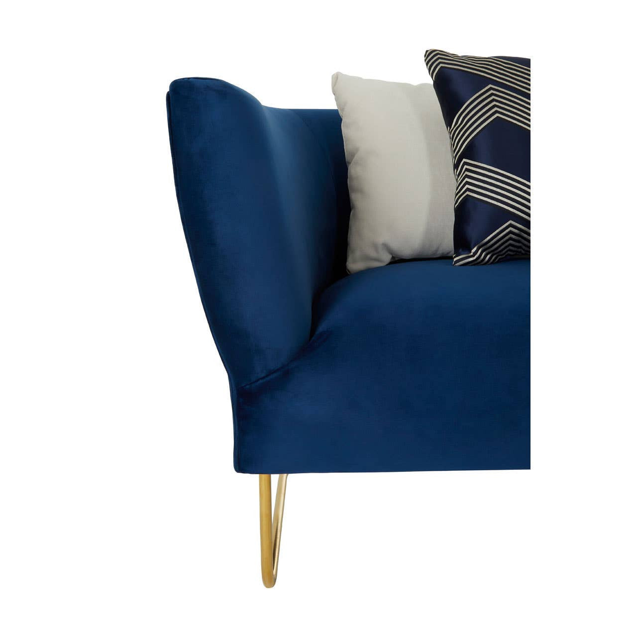 Dark blue velvet corner sofa featuring a curved armrest and elegant gold legs, accompanied by decorative cushions in various patterns and colors