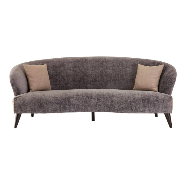 Three-seat sofa upholstered in grey velvet with a curved backrest and two contrasting beige throw pillows. The sofa features sleek wooden legs and a modern design, suitable for contemporary living spaces