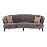 Three-seat sofa upholstered in grey velvet with a curved backrest and two contrasting beige throw pillows. The sofa features sleek wooden legs and a modern design, suitable for contemporary living spaces