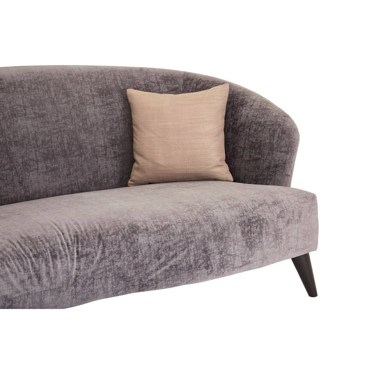 Grey velvet three-seat sofa with a curved backrest and a single beige decorative pillow on the seat, supported by tapered wooden legs