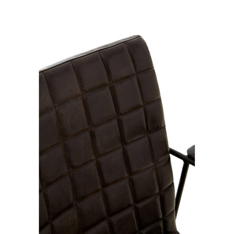 Closeup of quilted brown leather chair back with black metal arm detail