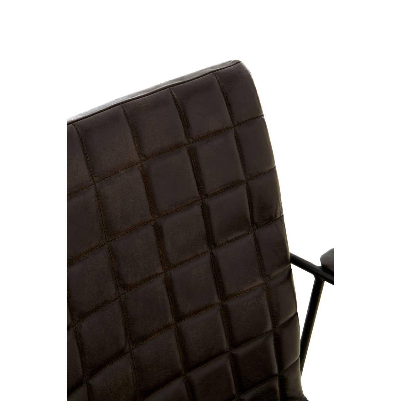 Closeup of quilted brown leather chair back with black metal arm detail