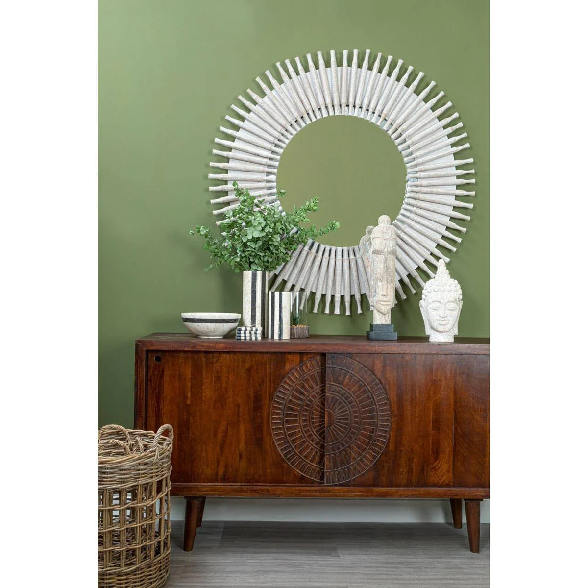 Mid-century wooden sideboard with carved doors, round mirror and home decor accents