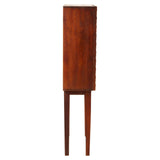Tall cabinet made of carved mango wood with a rich brown finish, featuring a cylindrical shape and four slender legs. The design highlights the natural grain of the wood, providing a coastal aesthetic suitable for home decor