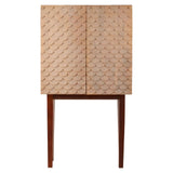 A coastal carved mango wood cabinet featuring a textured front with geometric patterns, two doors, and slender wooden legs. The cabinet has a natural wood finish that highlights the grain and craftsmanship